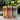 Three cans of BUCI Hard Kombucha on a table in a floral outdoor setting.