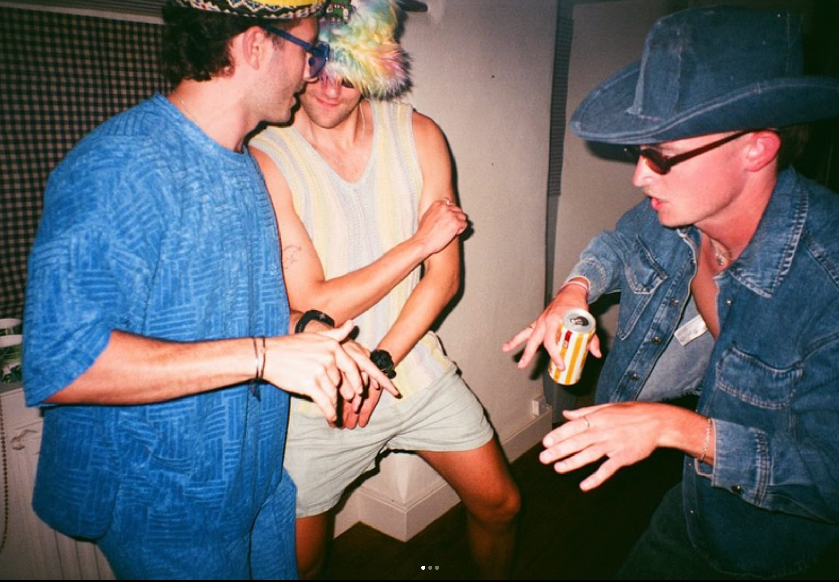 Three people dancing and holding cans of BUCI hard kombucha
